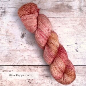 Mid pink merino & silk yarn on a cream base with darker speckles