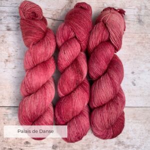 Three skeins of Merino and linen yarn in a deep rich pink