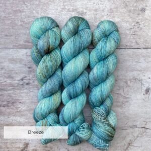 Three skeins of Merino & Silk in a light turquoise speckled in a warm brown