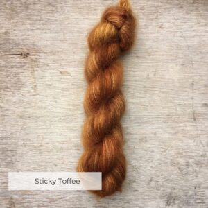 A single plump skein of mohair and silk in shades of caramel and toffee