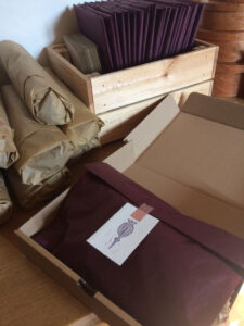 A packed up club box with wrapped yarn and packets behind it