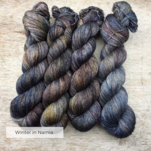 Four hanks of slightly silky yarn in shades of blue, brown, green, gold and plum