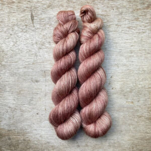 To skeins of soft lightly fluffy yarn in a deep crushed pink