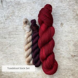 A full skein of Mohair sock in a dark blood red and two smaller skeins in a burgundy brown and a speckled cream