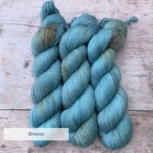 Three skeins of mohair sock in bright, sky blue with chocolate and gold speckles