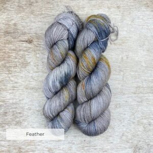 Two hanks of yarn blue and gold splashes on a light brown base