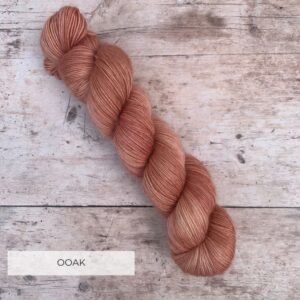 A single skein of floof in a pale terracotta pink