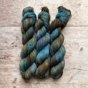 skeins of merino and mohair sock yarn in golden brown, denim and turquoise