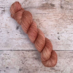 A single skein of floof in a pale terracotta pink
