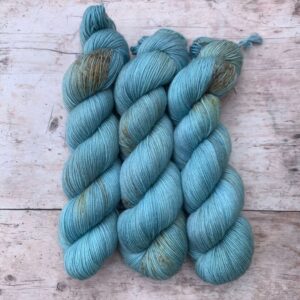 Three skeins of mohair sock in bright, sky blue with chocolate and gold speckles
