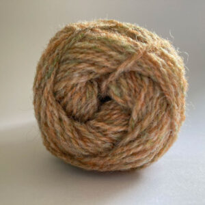Close up of the end of a ball of wool in a soft marled peach and green