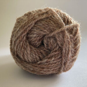 Close up of the end of a ball of wool in a soft marled brown