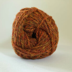 Close up of the end of a ball of wool in a rusty ginger