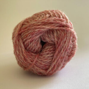 Close up of the end of a ball of wool in a soft marled pink