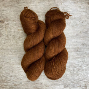 Two plump skeins of rich rust coloured wool