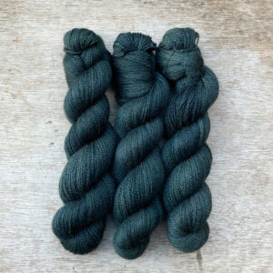 Three dark teal blue skeins of yarn