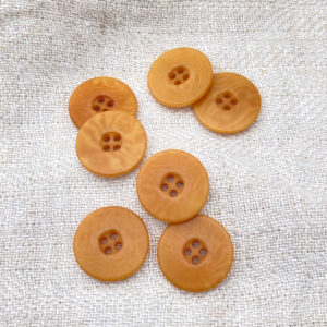 Ochre buttons on a linen background