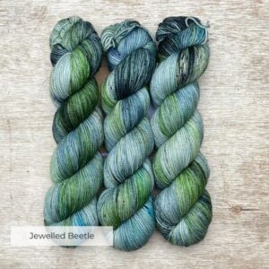 Three skeins of yarn in light blue, emerald and ink