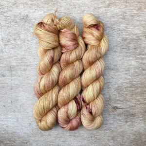 Golden, creamy yellow yarn splashed with orange and pink and wound into skeins