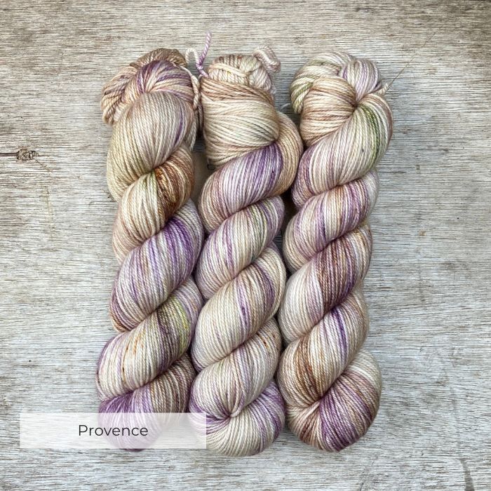 Three skeins of variegated yarn in lavender, coffee and green