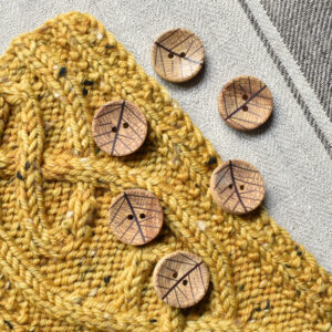 A scattering of olive wood buttons with a layered leaf design