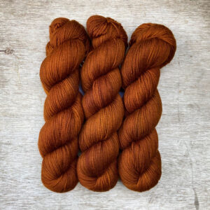 Three skeins of orange coppery yarn