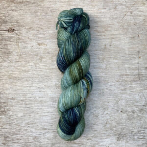Variegated yarn in green, teal and blue with rusty speckles