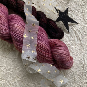 Two skeins of sock yarn on a crinkly background