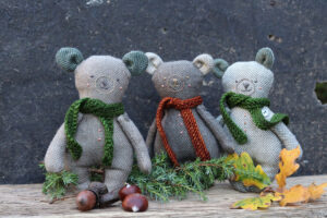 A row of tweedy bears against a slate background
