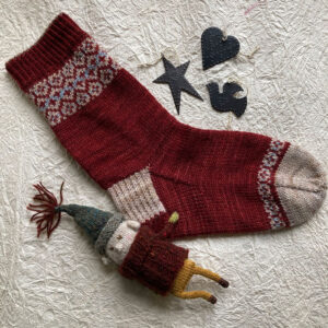 A fairisle sock in red with a stone colour heel and toe