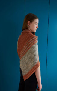 A young woman wearing a two coloured patterned shawl