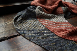 Two shawls on a dark wood background