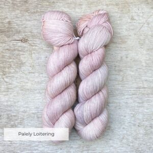 Two skeins of wool in pale pink, buff, grey and lilac