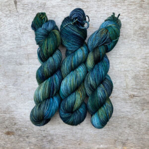 Three skeins of sock yarn in blue, emerald turquoise and yellow