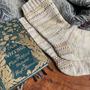 A pair of socks laying next to a book