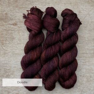 three skeins of yarn in brown, dusty pink and bronze