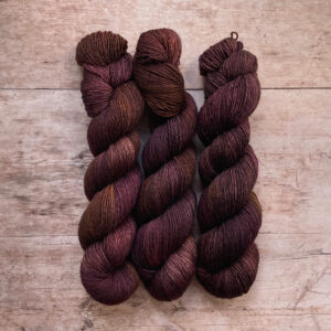 three skeins of Merino & Silk wool in brown, dusty pink and bronze