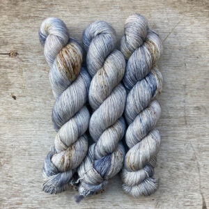 Three skeins of denim and grey wool freckled with brown