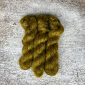 Three skeins of mohair lace in a glowing yellow green