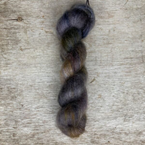 A single skein of mohair lace in shades of grey, blue and gold