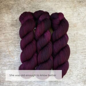 Three skeins of plump DK wool in deep plum purple