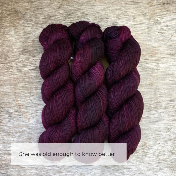 Three skeins of plump DK wool in deep plum purple