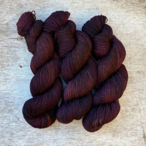 three skeins of yarn in brown, dusty pink and bronze