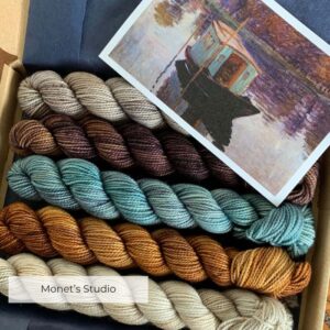 Five mini skeins of sock yarn in a tissue lined box along with the picture that inspired their colours