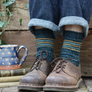 A pair of feet in brown shoes and stripes socks