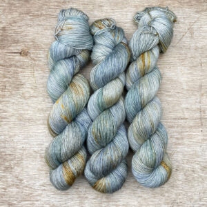 Three skeins of a pale blue green with splashes of yellow
