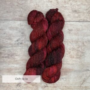 skeins of Merino and linen yarn in a rich red and dark pink