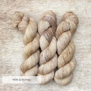 Three skeins of merino and linen in buttercream, coffee and gold