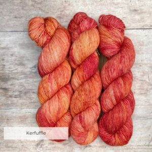 skeins of merino and linen yarn in shades of bright peach, shocking pink and orange