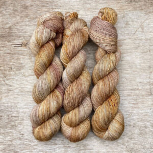 Three skeins of merino and linen in gold and pink